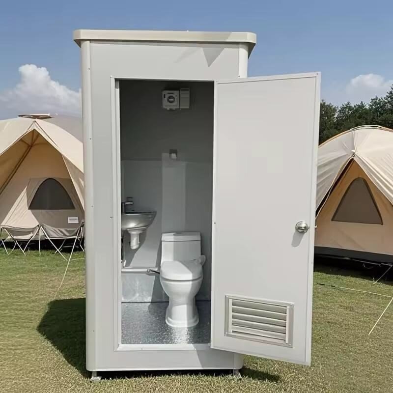 Deluxe restroom unit with open door showing sink and toilet, set up near event tents